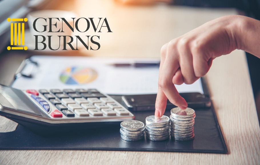 silver coins next to a calculator and clipboard on top of a wooden desk